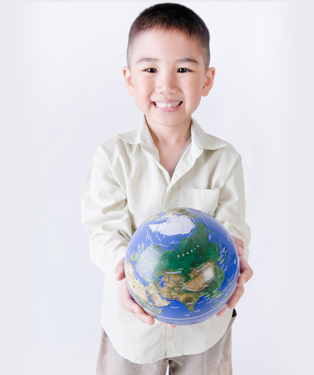 Child holding a globe in his hands.
